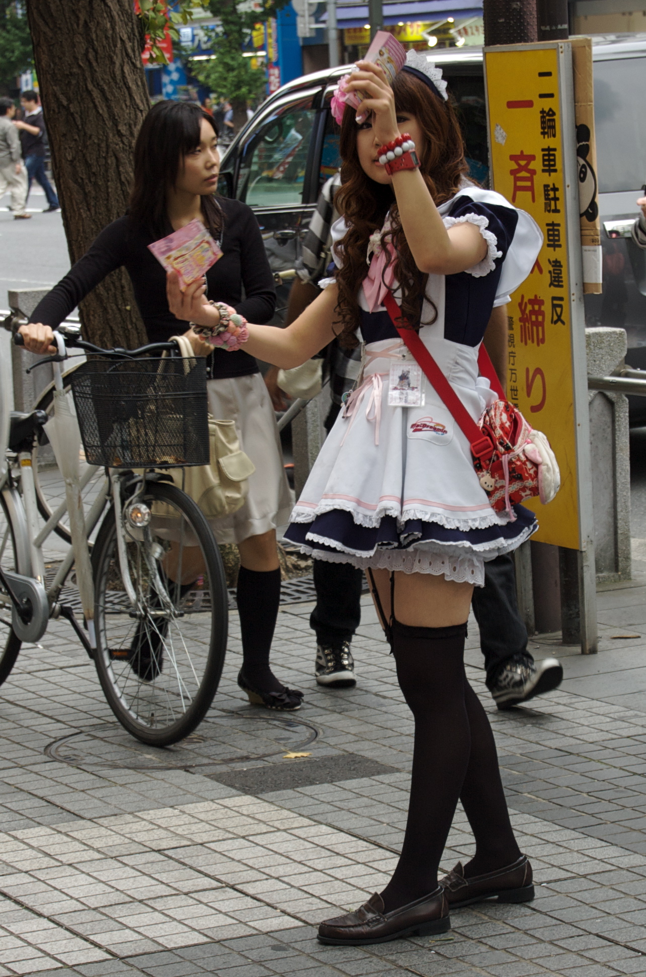 Maid in front of a maid cafe in Japan
